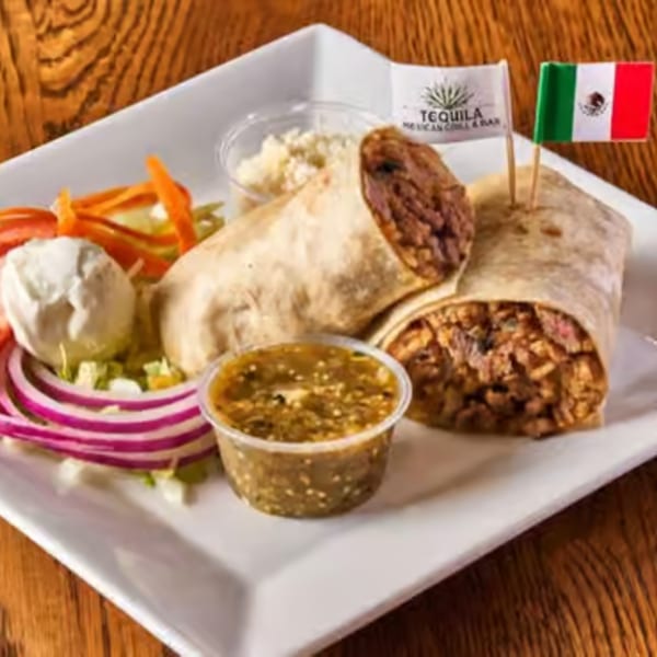 Two burritos with sides of salsa, sour cream, and salad, garnished with Mexican flags.