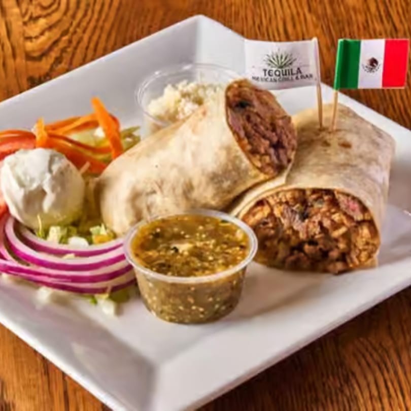 Two burritos with sides of salsa, sour cream, and salad, garnished with Mexican flags.